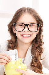 Image showing little girl with piggy bank and money