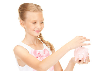 Image showing lovely teenage girl with piggy bank and money