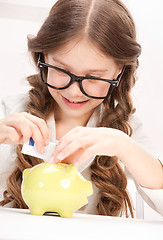 Image showing little girl with piggy bank and money