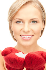 Image showing beautiful woman in red mittens with snow