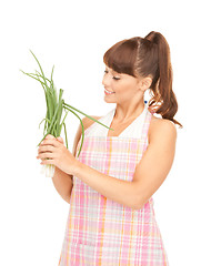 Image showing beautiful housewife with spring onions over white