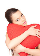 Image showing woman with red heart-shaped pillow over white