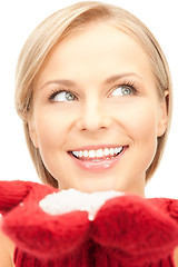 Image showing beautiful woman in red mittens with snow