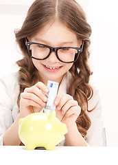 Image showing little girl with piggy bank and money