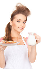 Image showing housewife with milk and cookies