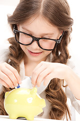 Image showing little girl with piggy bank and money