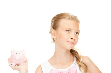 Image showing lovely teenage girl with piggy bank