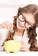 Image showing little girl with piggy bank and coin