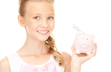 Image showing lovely teenage girl with piggy bank and money