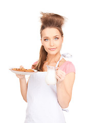 Image showing housewife with milk and cookies