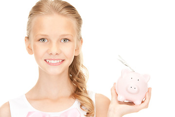 Image showing lovely teenage girl with piggy bank and money