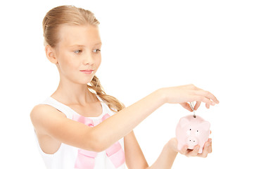 Image showing lovely teenage girl with piggy bank and money