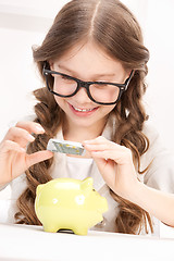 Image showing little girl with piggy bank and money