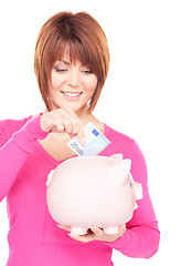 Image showing lovely woman with piggy bank and money