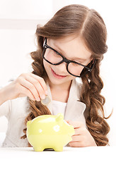 Image showing little girl with piggy bank and coin