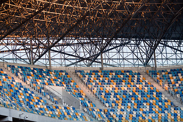 Image showing Tiered seats sit empty in large sports stadium