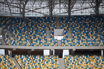 Image showing Tiered seats sit empty in large sports stadium