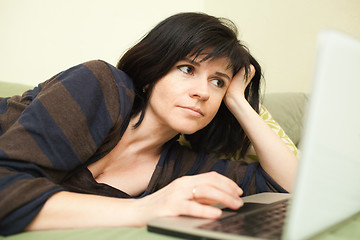 Image showing Woman with laptop on sofa