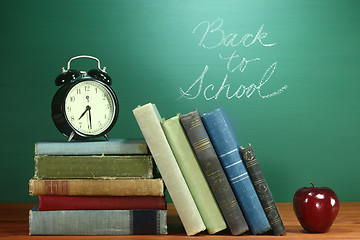 Image showing School Books, Apple and Clock on Desk at School