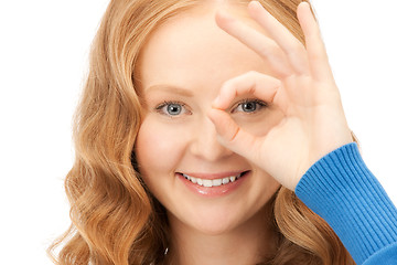 Image showing lovely woman looking through hole from fingers