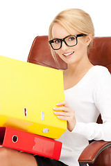 Image showing young businesswoman with folders sitting in chair