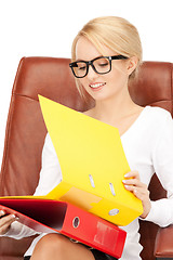 Image showing young businesswoman with folders sitting in chair