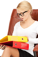 Image showing young businesswoman with folders sitting in chair