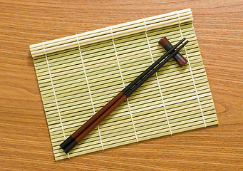 Image showing Bamboo mat with chopsticks

