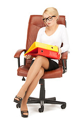 Image showing young businesswoman with folders sitting in chair