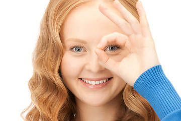 Image showing lovely woman looking through hole from fingers