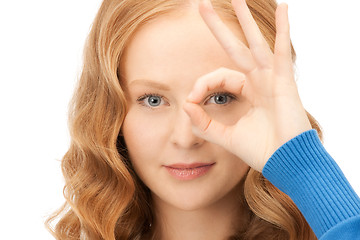 Image showing lovely woman looking through hole from fingers