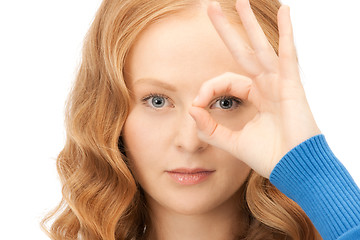 Image showing lovely woman looking through hole from fingers