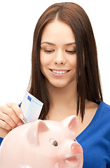 Image showing lovely woman with piggy bank and money