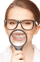 Image showing woman with magnifying glass showing teeth