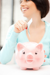 Image showing lovely woman with piggy bank and money