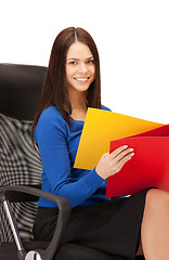 Image showing young businesswoman with folders sitting in chair