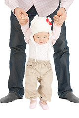 Image showing baby making first steps with father help