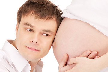 Image showing male face and pregnant woman belly