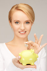 Image showing lovely woman with piggy bank and money