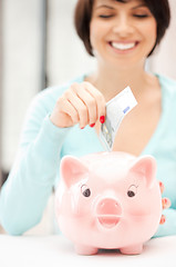 Image showing lovely woman with piggy bank and money