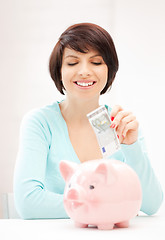 Image showing lovely woman with piggy bank and money