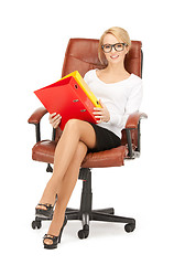 Image showing young businesswoman with folders sitting in chair