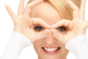 Image showing lovely woman looking through hole from fingers
