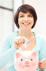 Image showing lovely woman with piggy bank and money