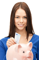 Image showing lovely woman with piggy bank and money