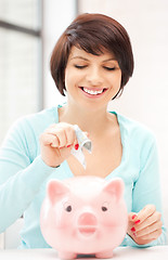 Image showing lovely woman with piggy bank and money