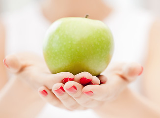 Image showing female hands with green apple