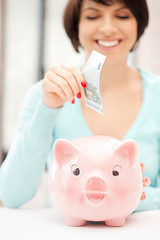 Image showing lovely woman with piggy bank and money