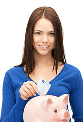 Image showing lovely woman with piggy bank and money