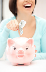 Image showing lovely woman with piggy bank and money